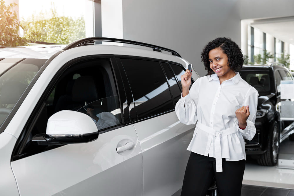 Cliente satisfeita a receber chaves de SUV branco da frota GIRAR Rent a Car